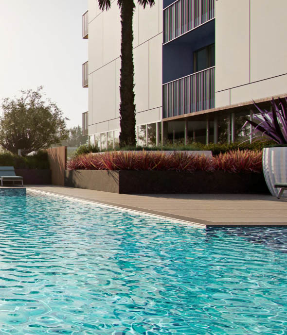 Citrus Commons pool area with sparkling blue water and lush landscaping.